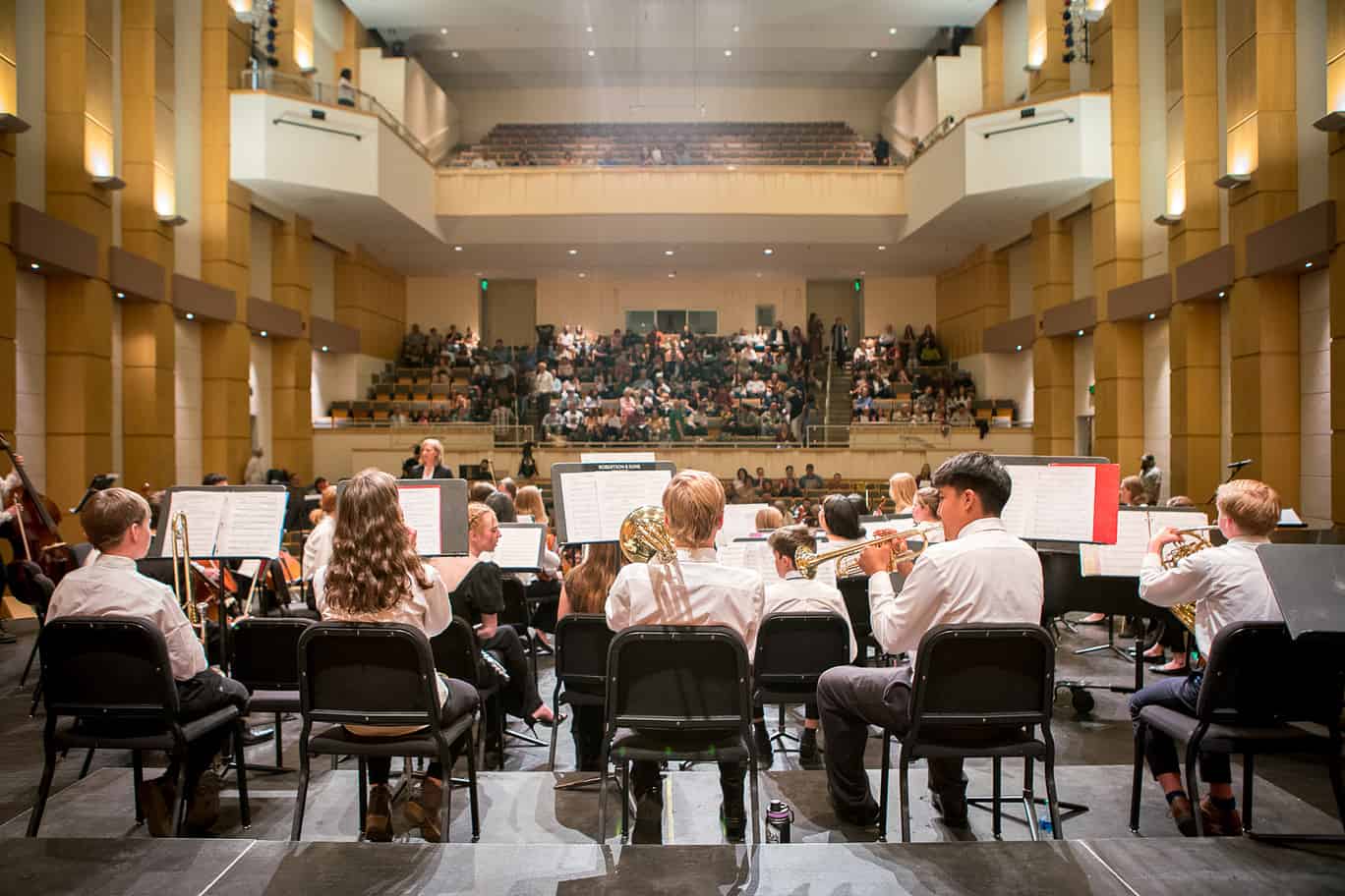 Photo behind youth musicians on stage, looking out at the audience