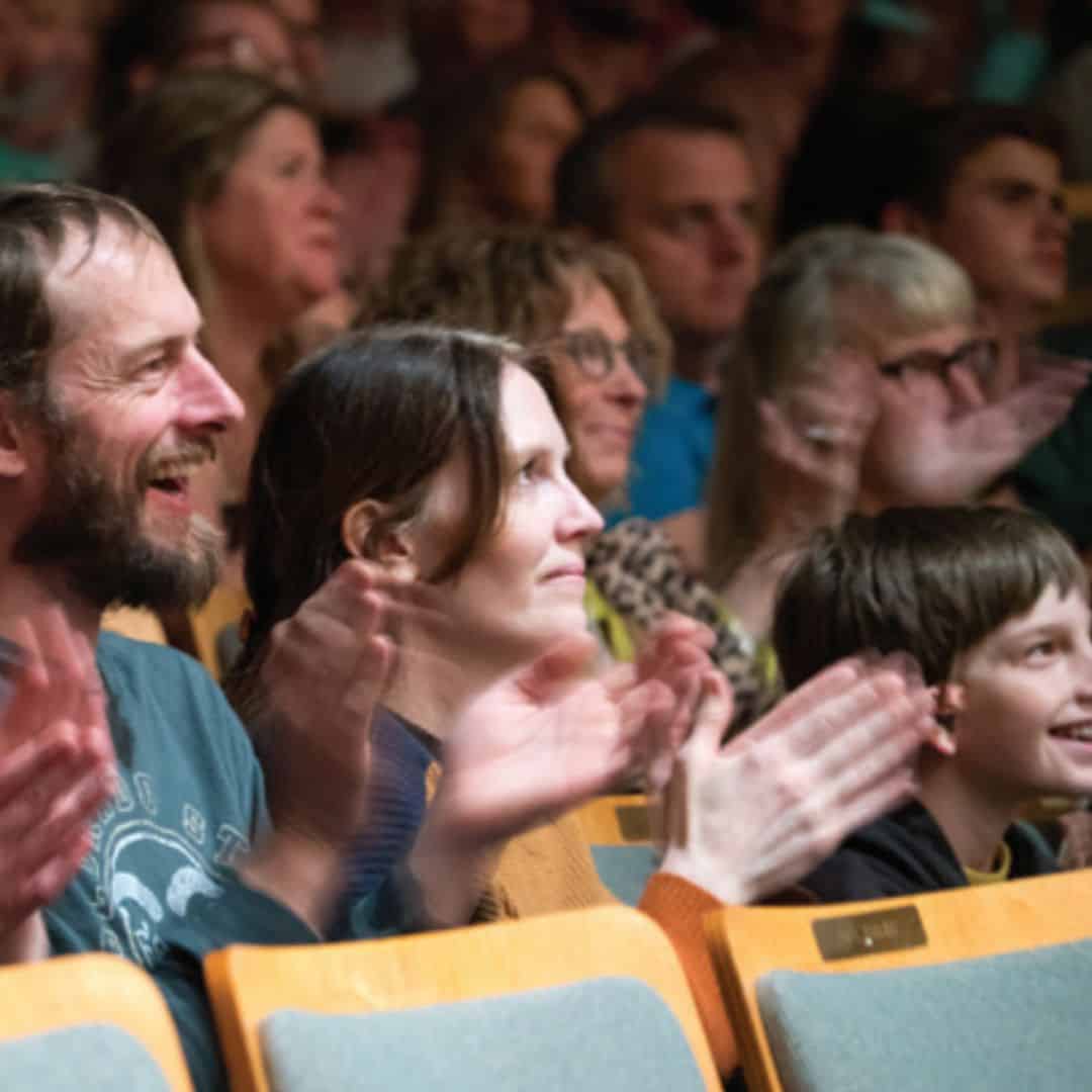 Adults and children applauding and smiling
